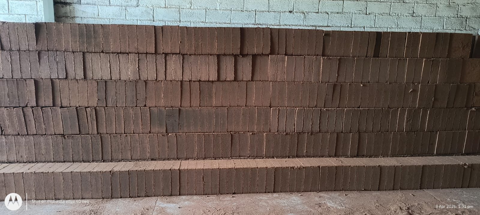 Wall of coco peat 5 kg blocks in stock at a Tamil Nadu production unit